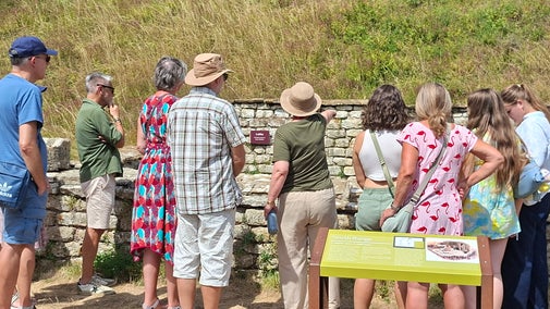 Visitors to Chedworth Roman Villa with a tour guide